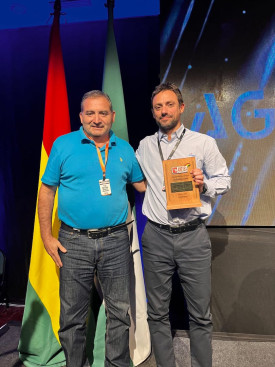 Two men on stage with certificate